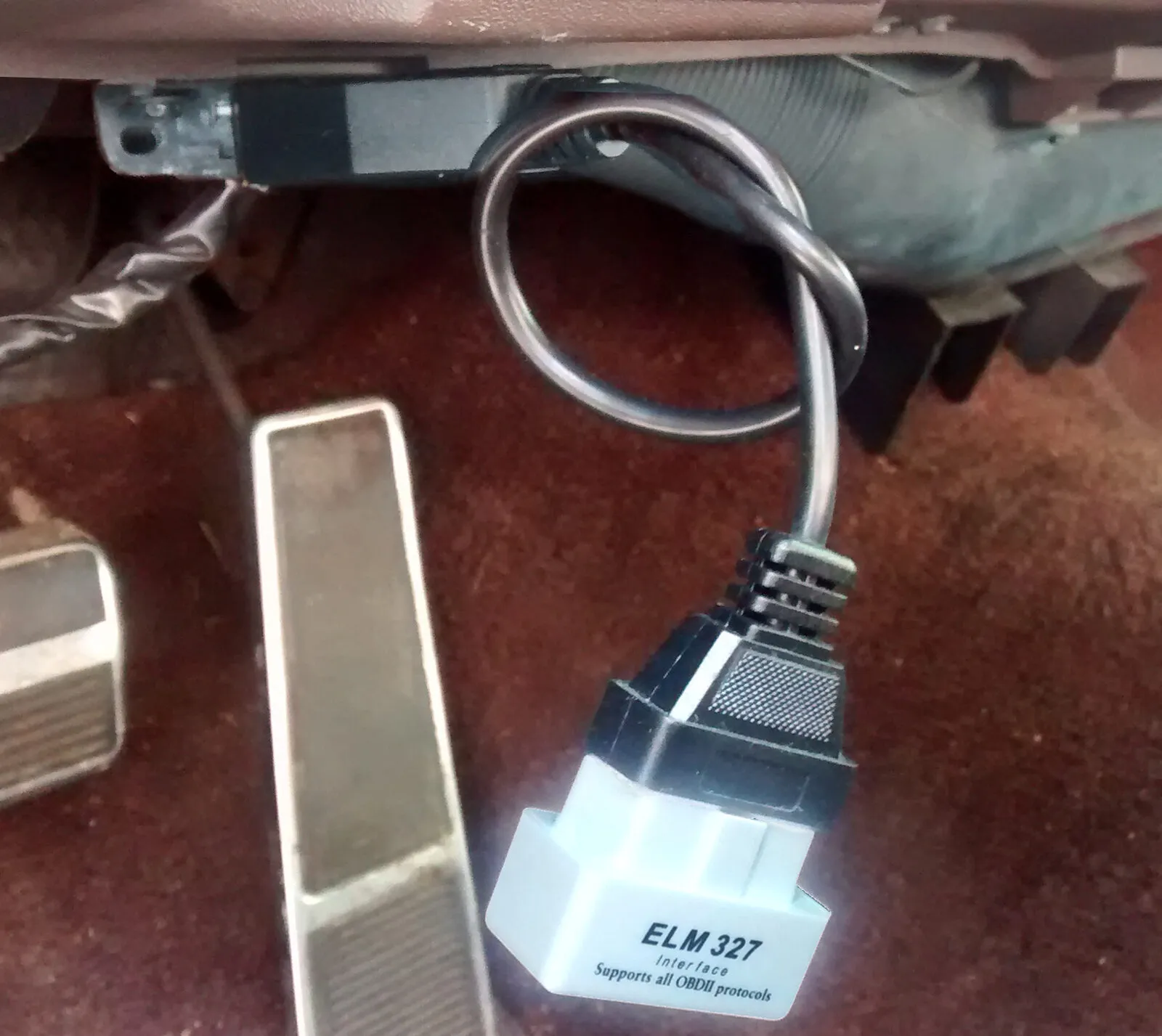 ELM327-adapter in de OBD2-aansluiting onder het dashboard, naast de pedalen