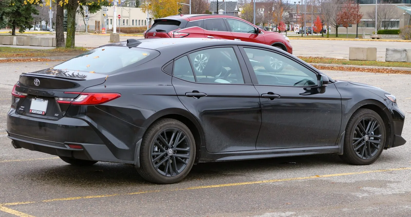 2025 Toyota Camry Hybrid SE in Midnight Black, rear three-quarter view