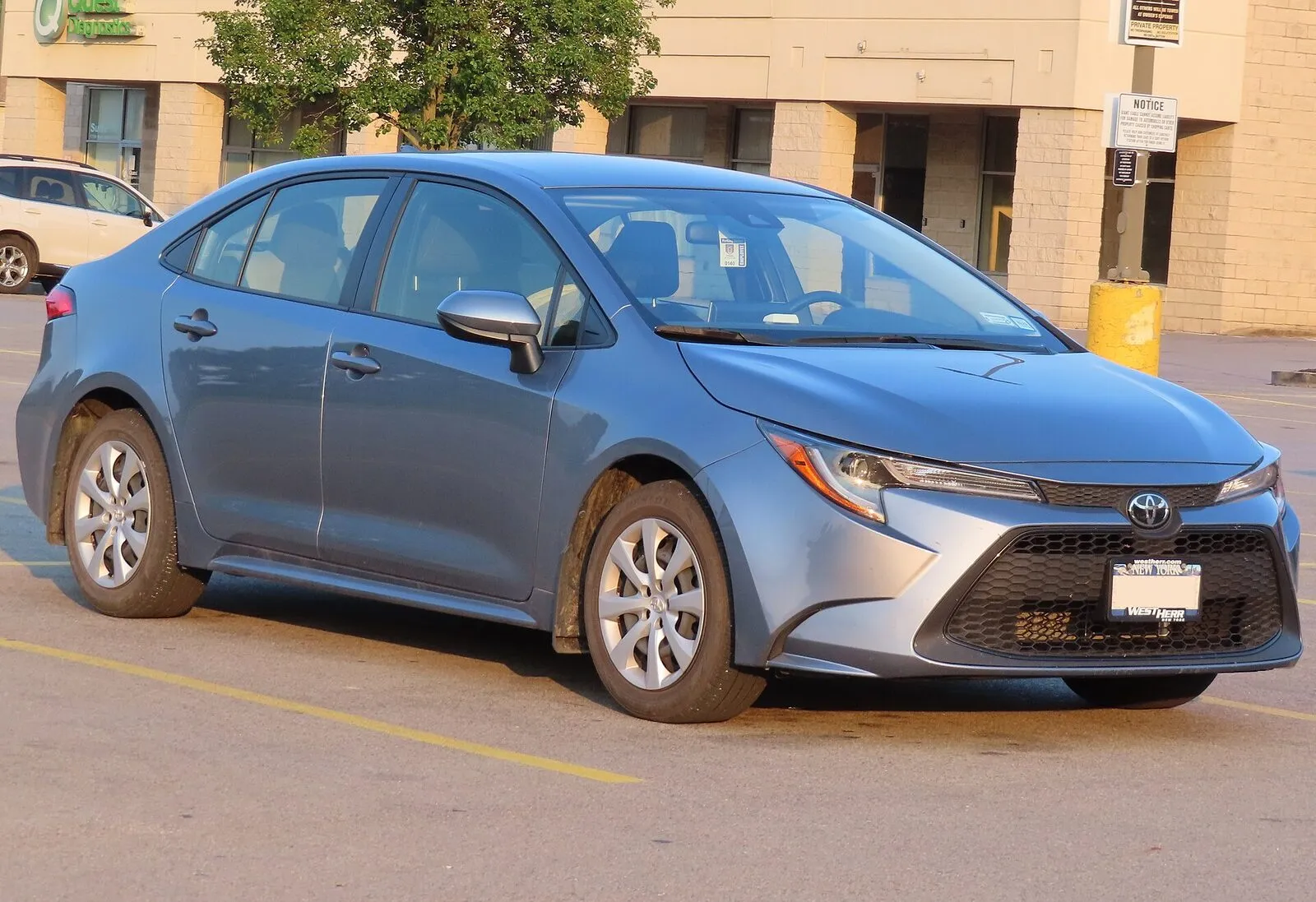 Toyota Corolla sedan in blue, front three-quarter view in a parking lot
