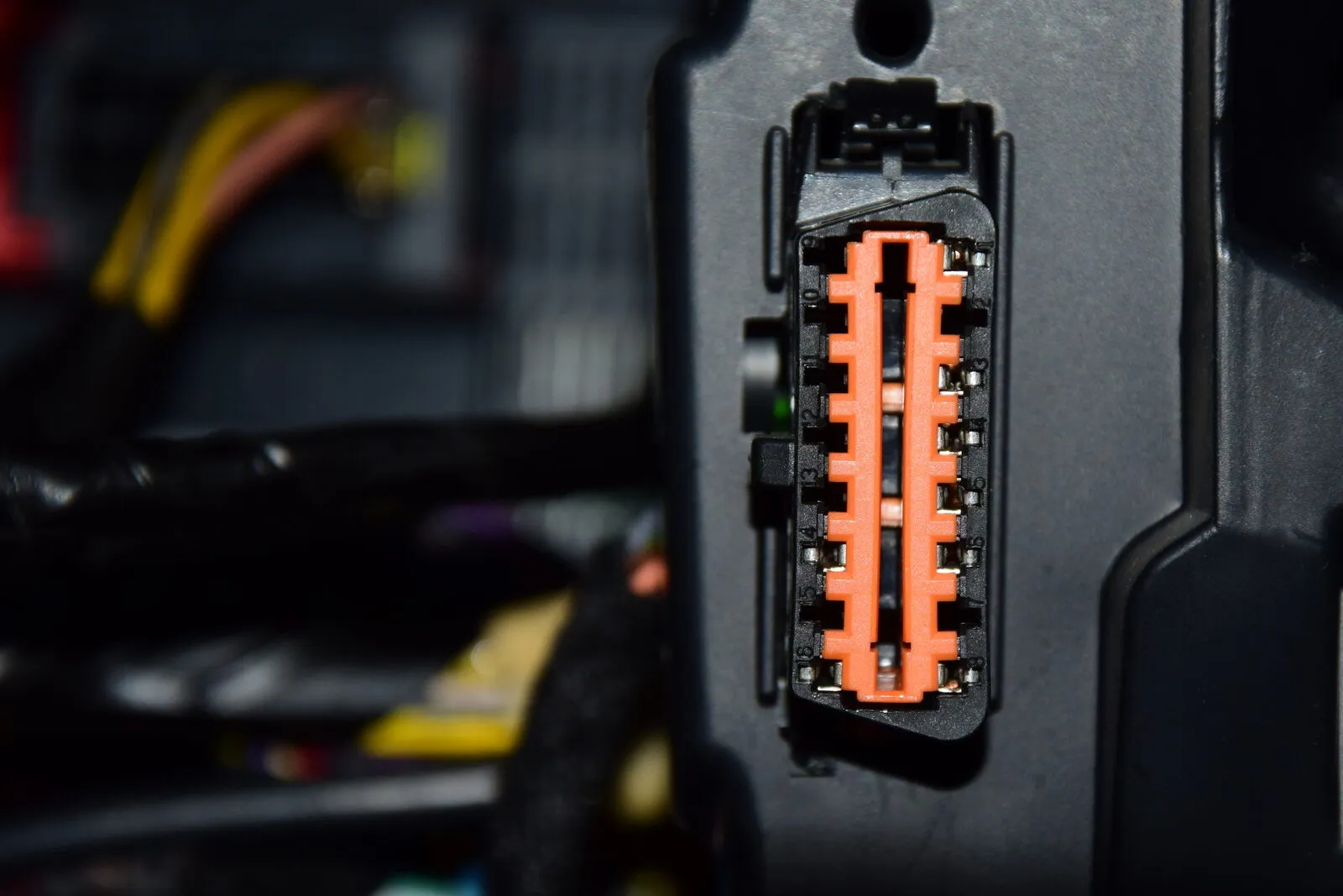 The 16-pin OBD2 diagnostic connector under a car dashboard