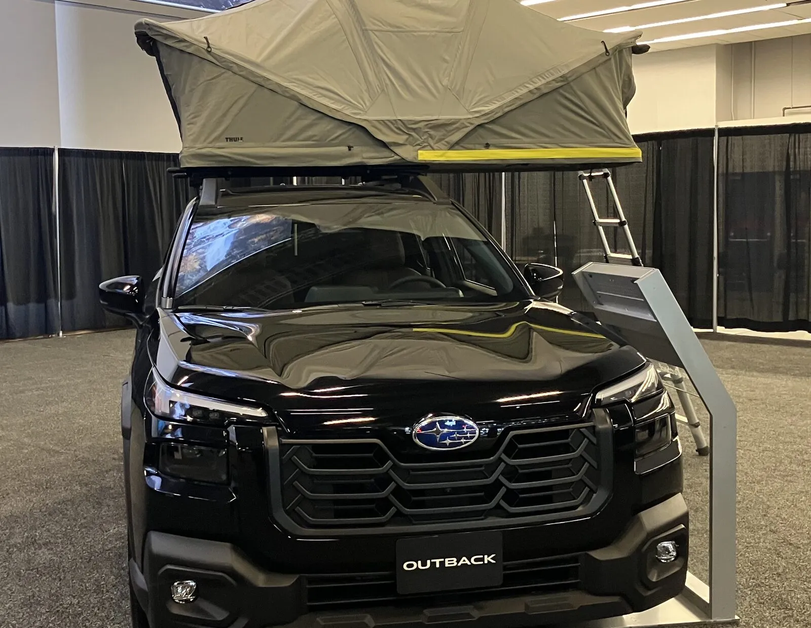 Black 2026 Subaru Outback with a rooftop tent, front view at the 2026 Montréal auto show