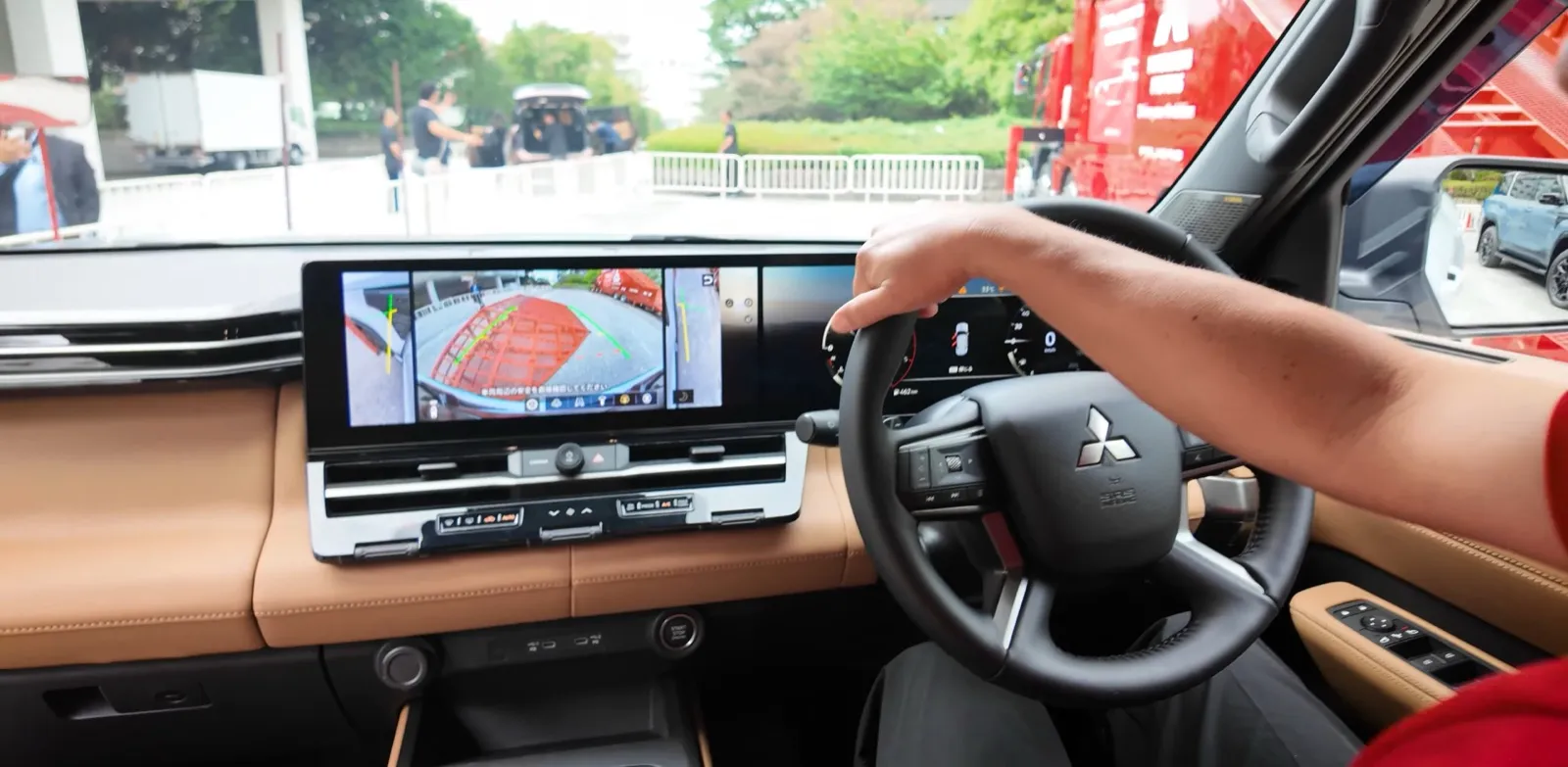 Interieur van de nieuwe Mitsubishi Pajero: doorlopend 14,3-inch display, bruin leer en het rechtsgestuurde stuur van de Japanse versie