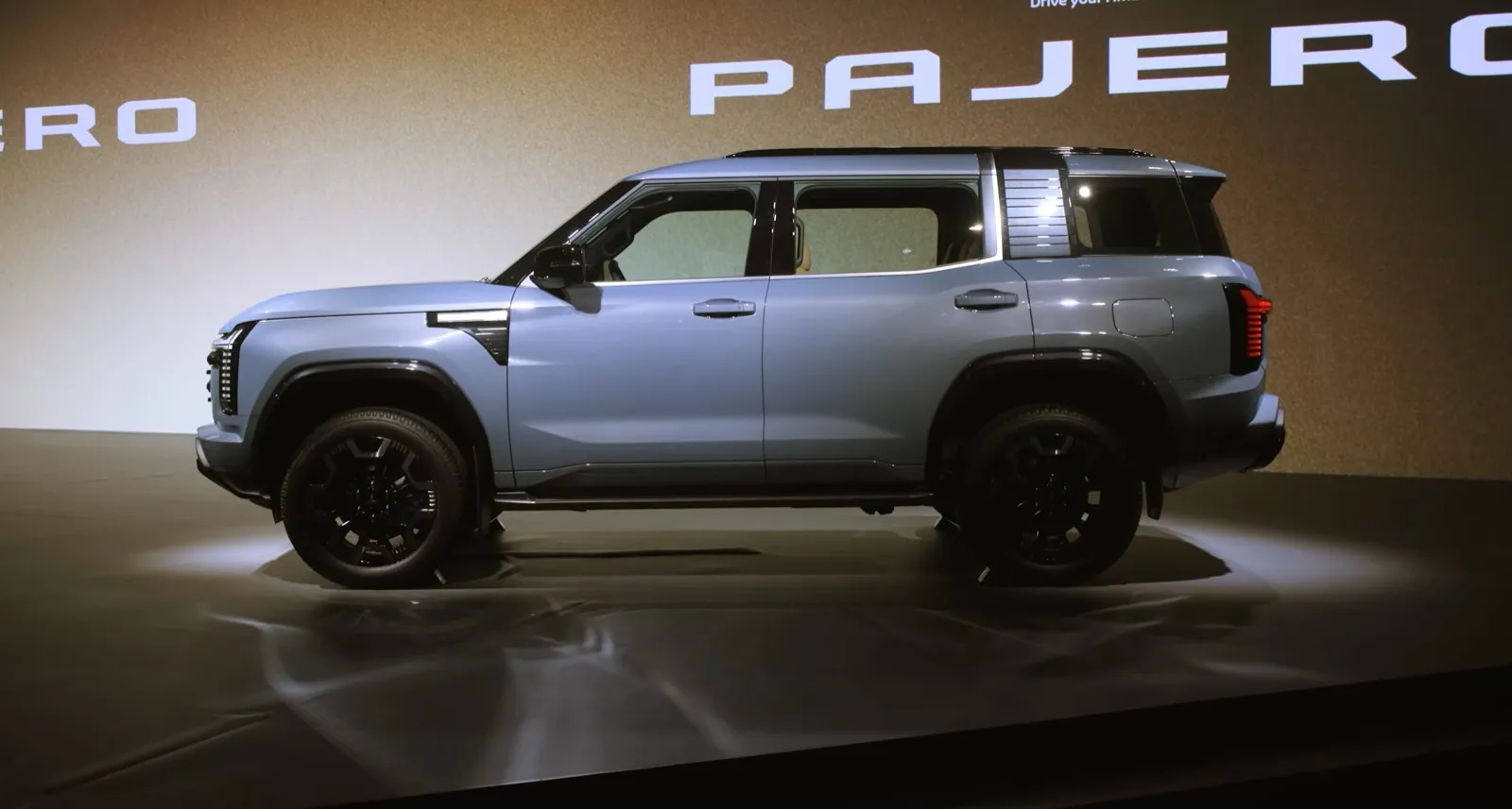 De nieuwe Mitsubishi Pajero 2026 in profiel op het podium van de wereldpremière in Tokio
