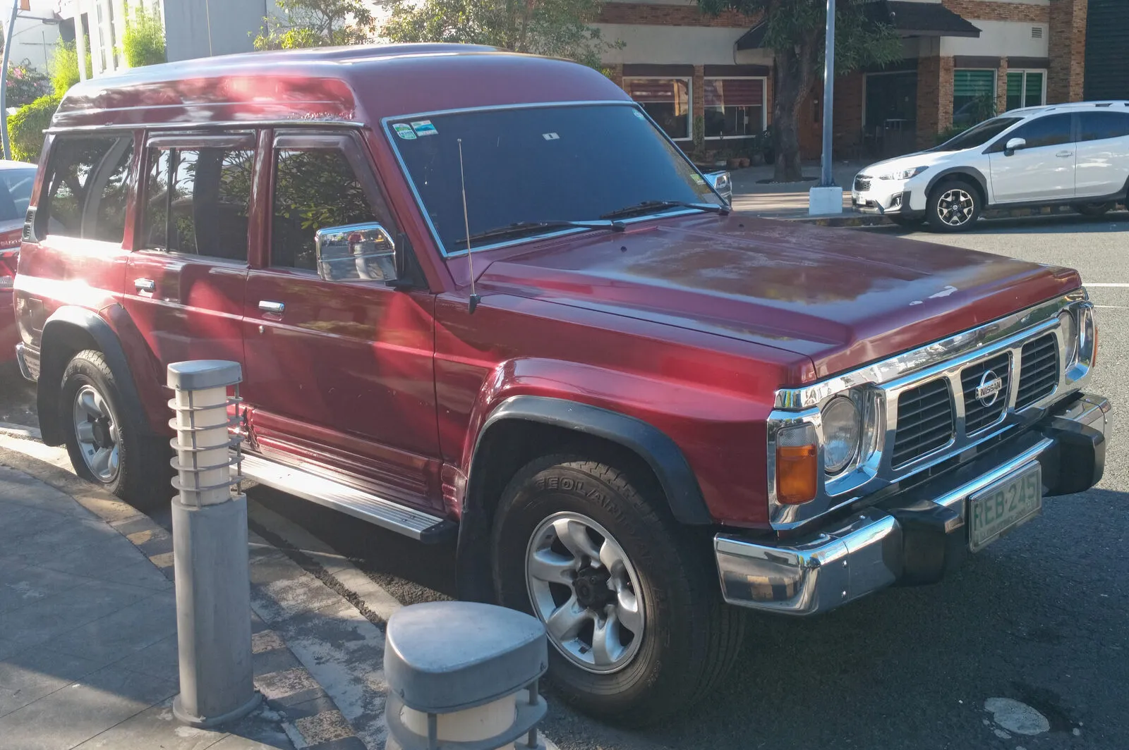 Dark red 1995 Nissan Patrol Y60 2.8 diesel parked on a street, front three-quarter view