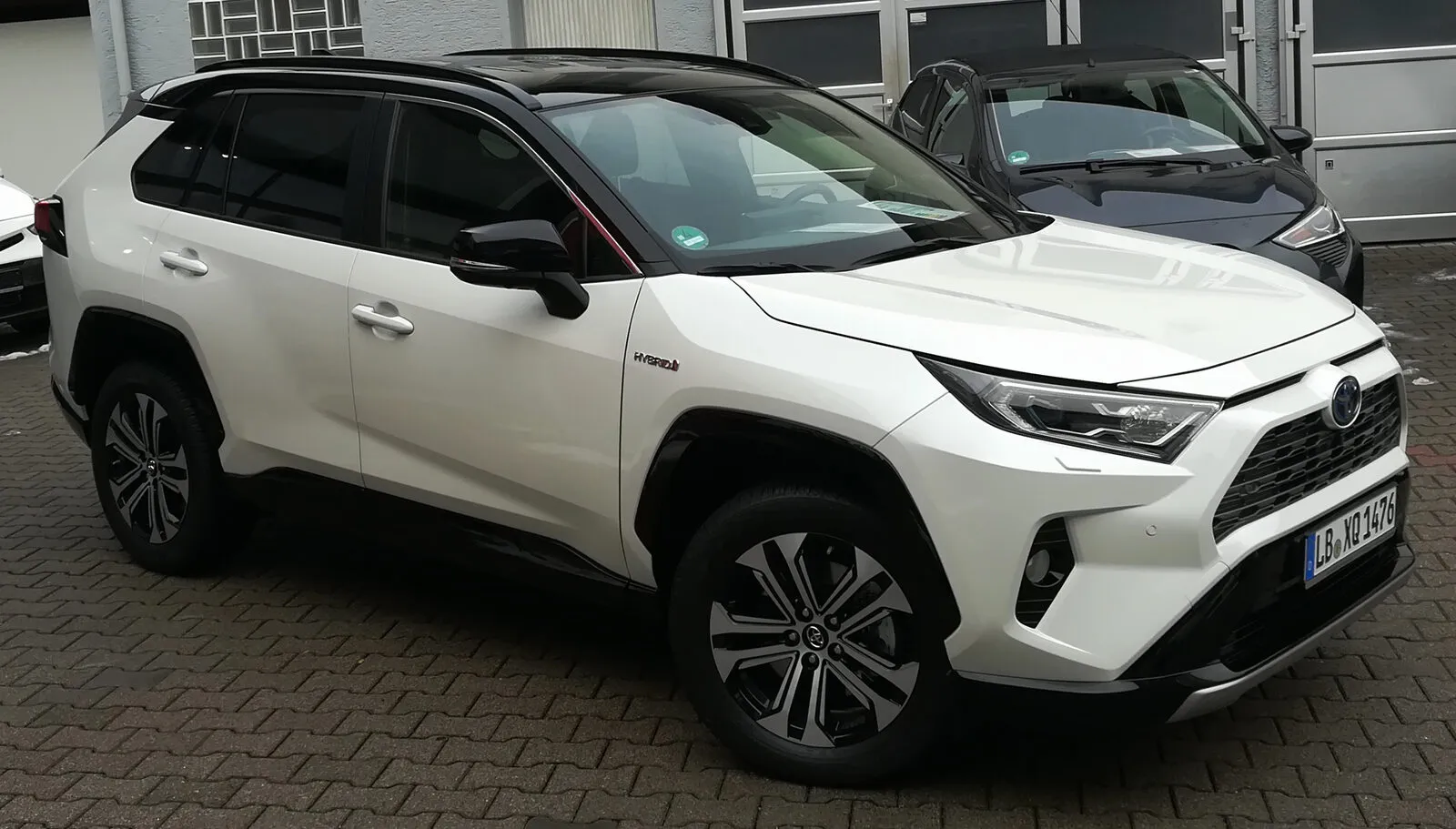 Toyota RAV4 Hybrid of the fifth generation in white, front three-quarter view