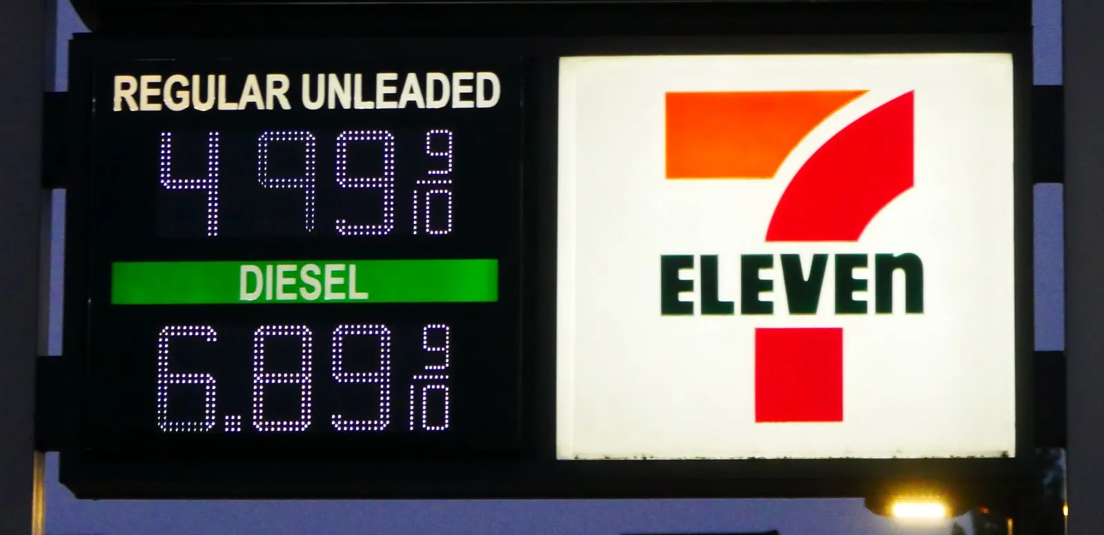 Illuminated price board showing regular unleaded at $4.99 and diesel at $6.89 a gallon in Eugene, Oregon