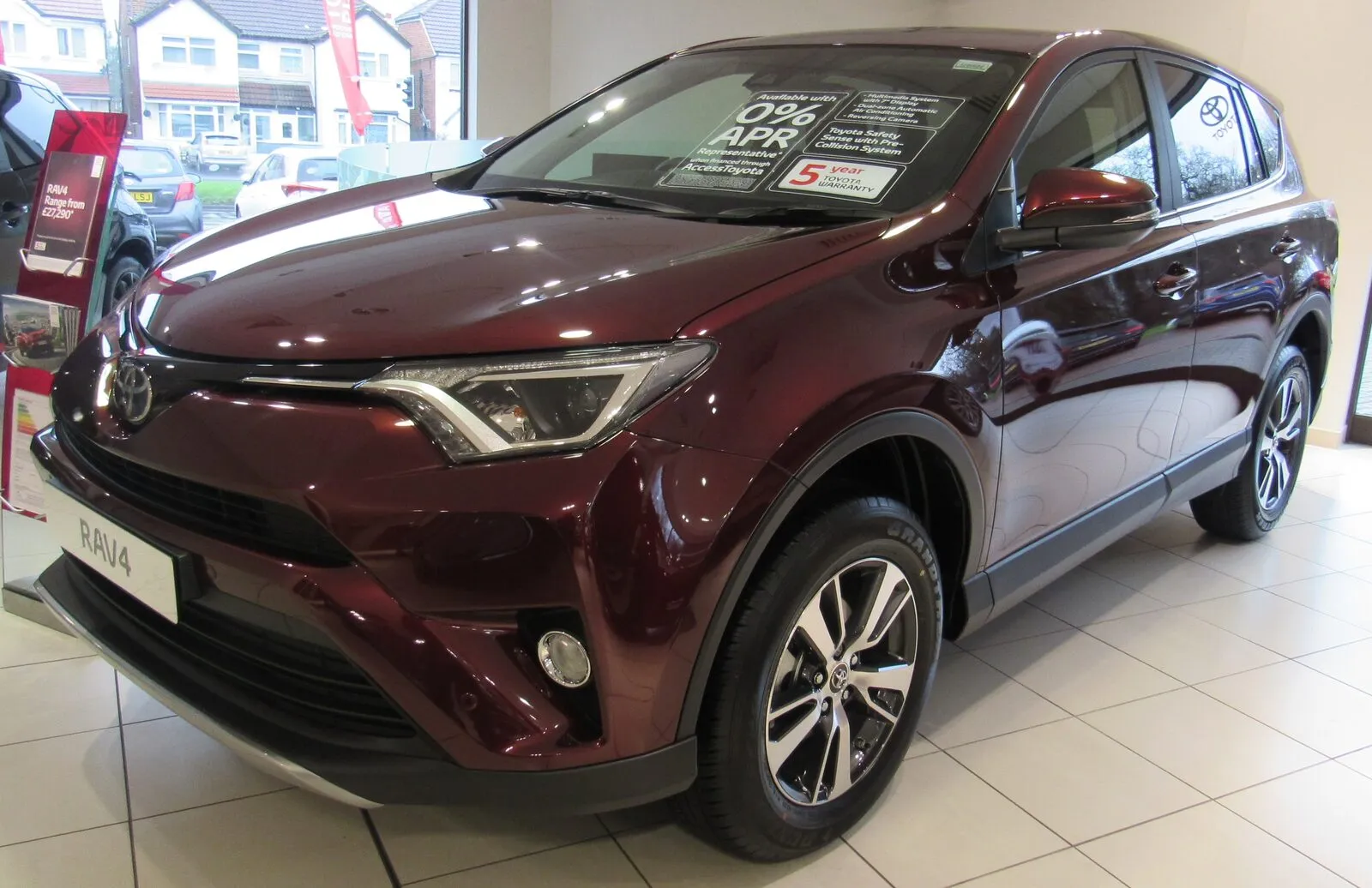 Donkerrode Toyota RAV4 2.0 D-4D, facelift-model 2017, in een Toyota-showroom