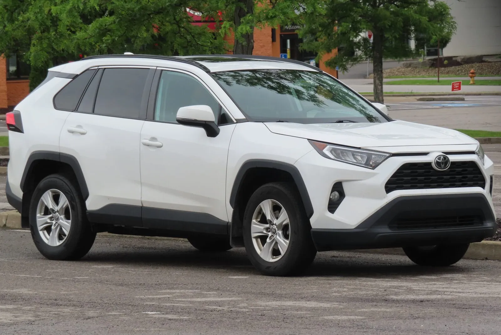 White 2021 Toyota RAV4 XLE AWD with the gas engine, front three-quarter view, in a parking lot