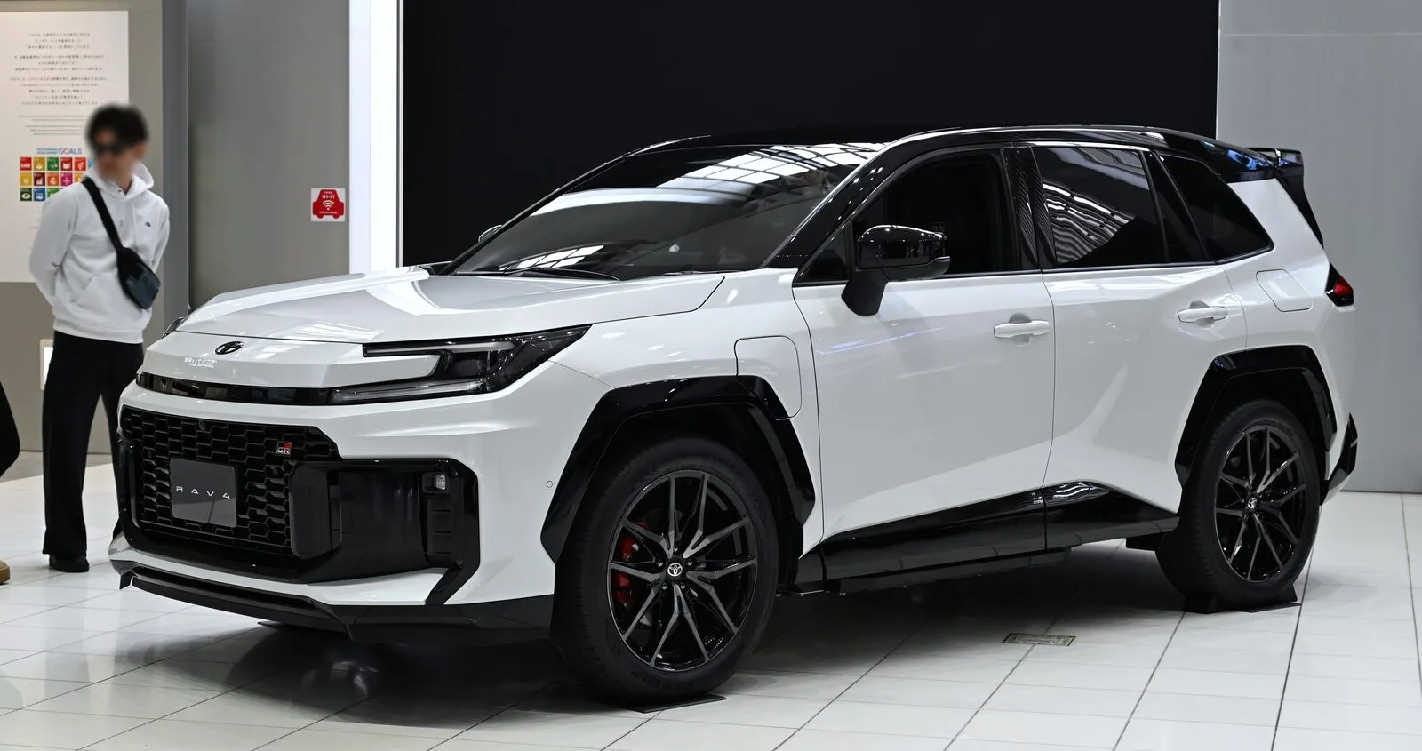 Witte Toyota RAV4 plug-in hybride in GR Sport-uitvoering met zwart dak, als prototype op een beursvloer